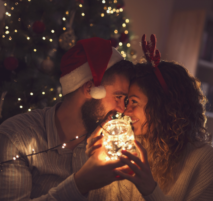 ζευγάρι μπροστά από το χριστουγεννιάτικο δέντρο
